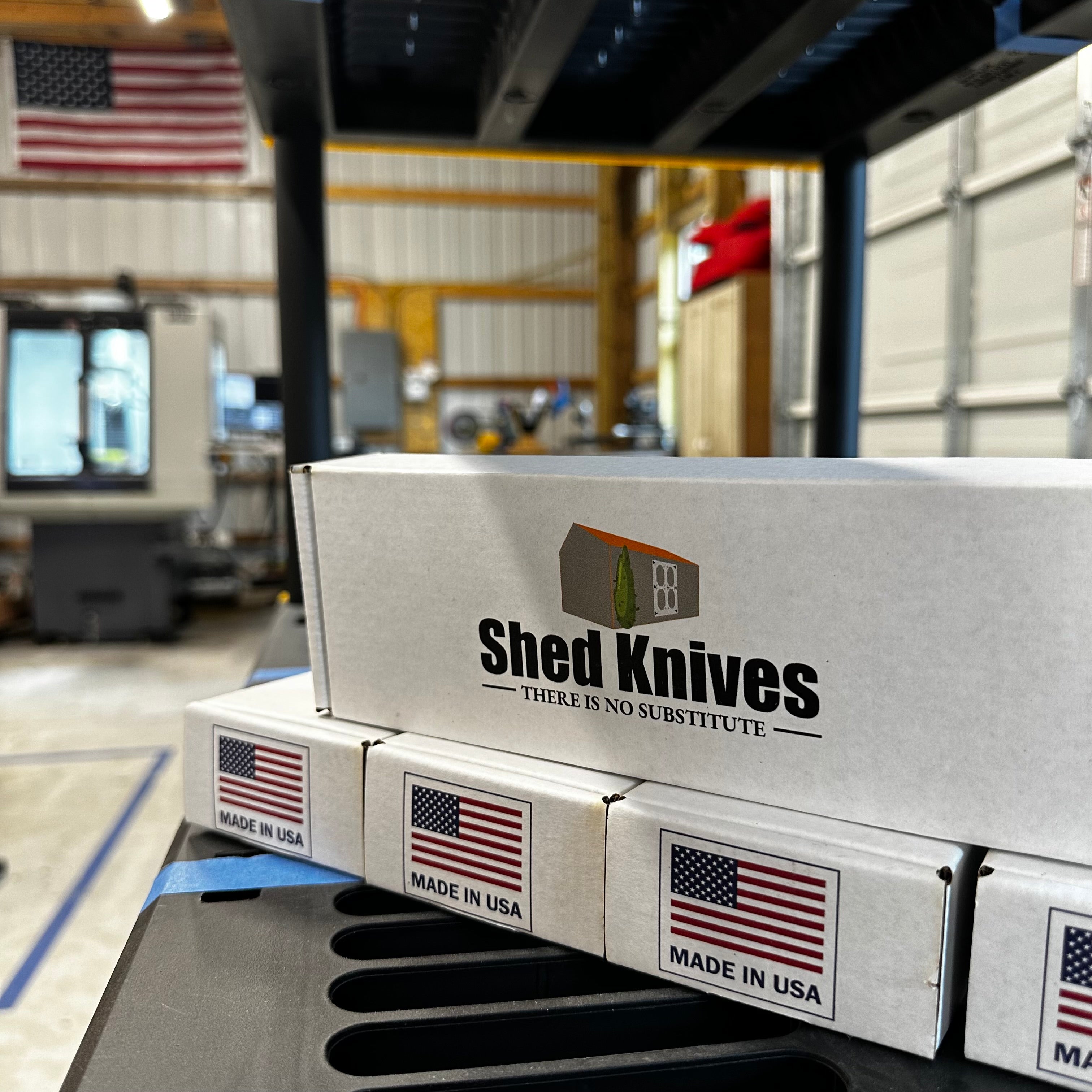 Shed Knives U.S. workshop CNC milling station producing blades with boxes on shelf showing high standards.