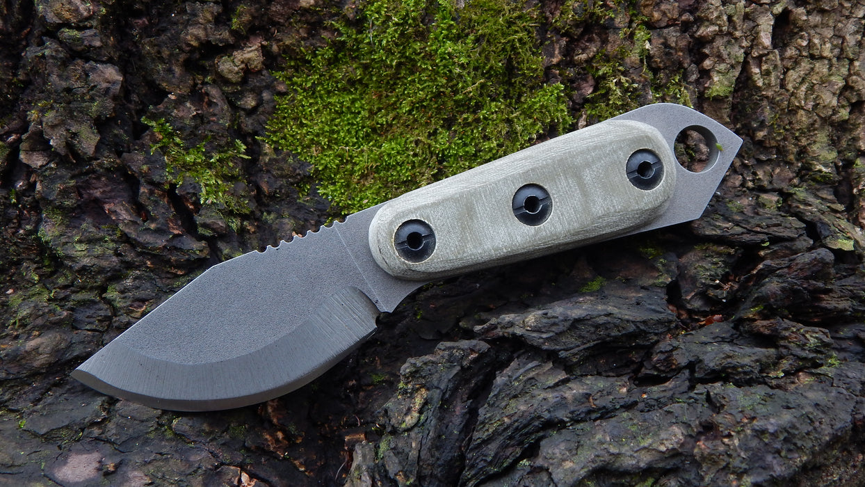 2023 Shed Knives Skur in OD Green G-10 sitting on mossy wood.